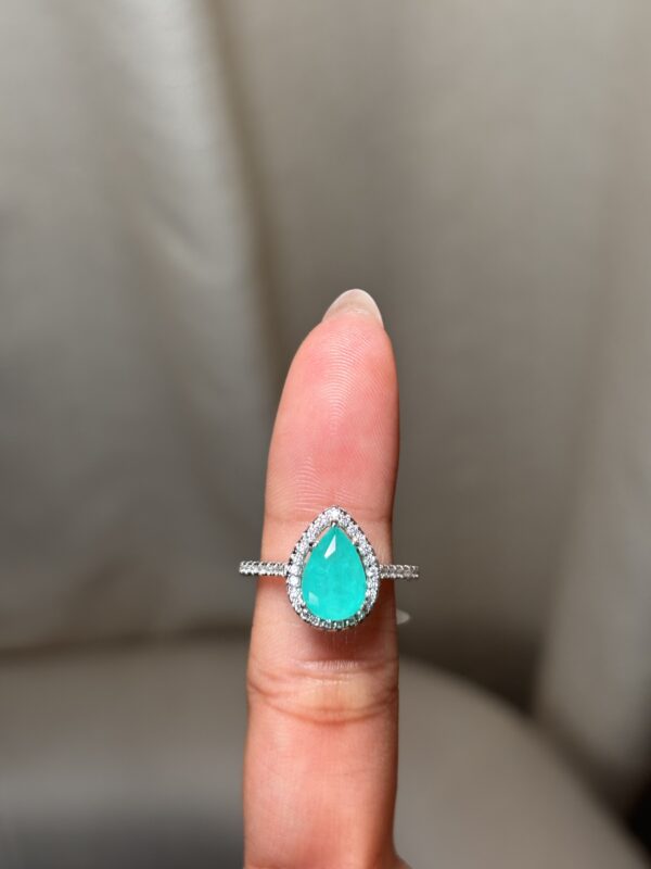 Anillo de diseño halo con gema central corte gota verde claro y banda pavé